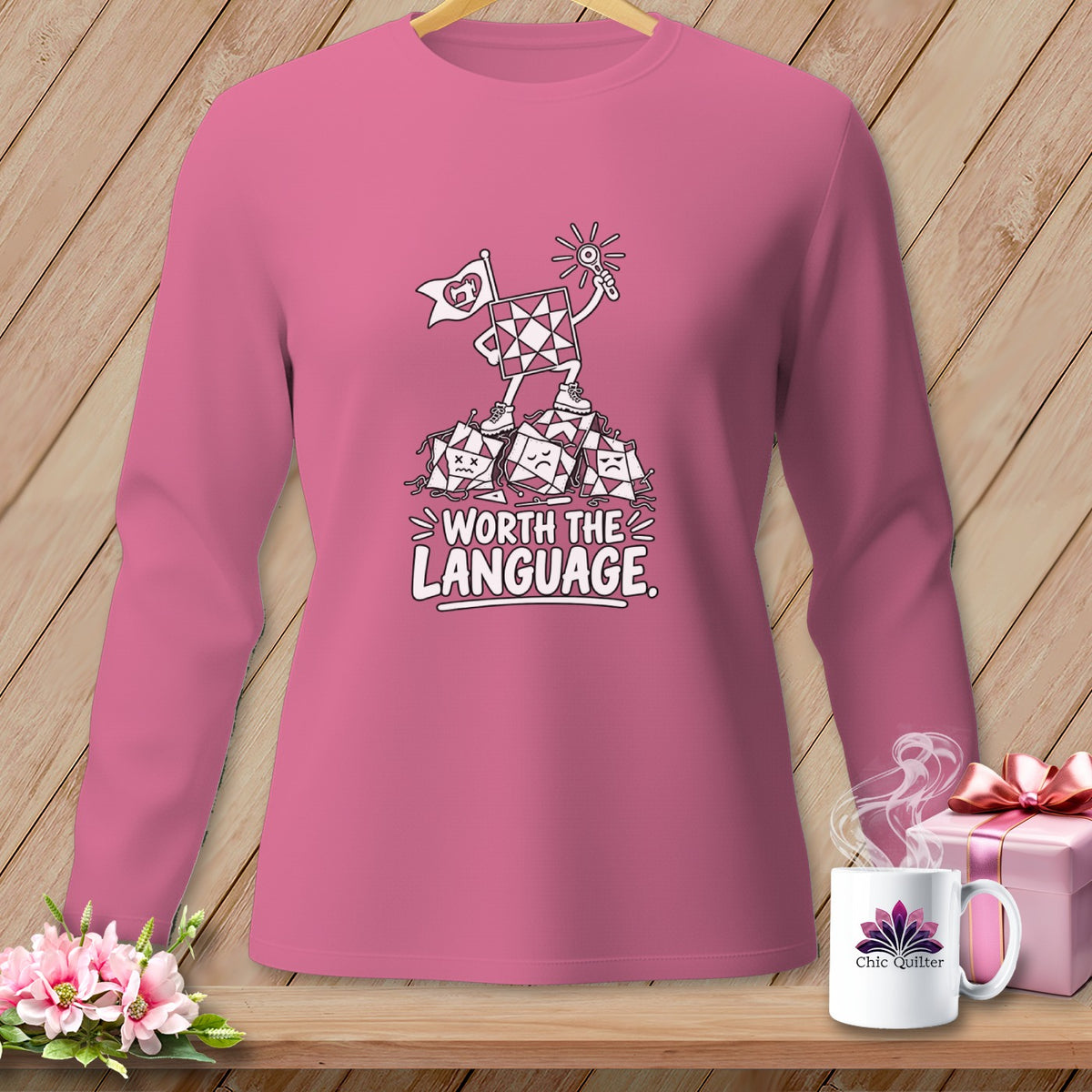 Pink long sleeve shirt with cartoon quilt blocks and "Worth the Language" text.
