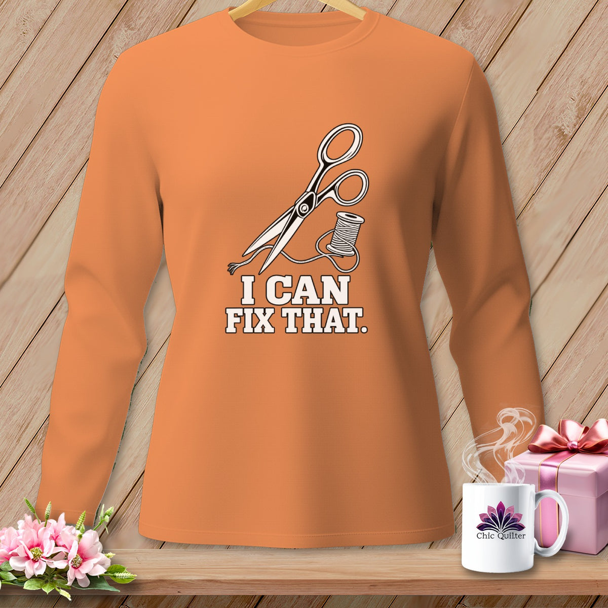 Orange long-sleeve shirt with scissors, thread, and text "I CAN FIX THAT."