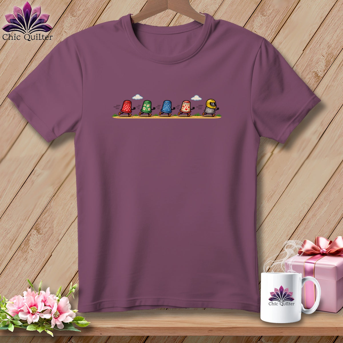 Plum crew neck t-shirt featuring a cartoon illustration of five racing thimbles on the chest.