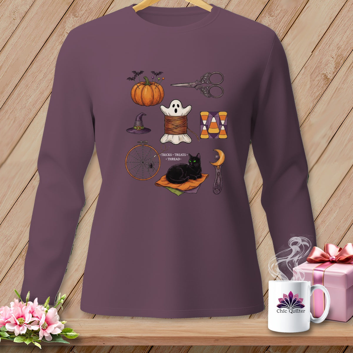 Long-sleeve shirt featuring Halloween-themed sewing items, including a pumpkin, ghost, and black cat.
