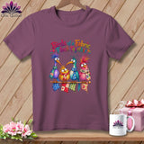 Plum t-shirt featuring four colorful, whimsical cartoon birds perched on a spool with the text Birds of a Fabric Flock Together.