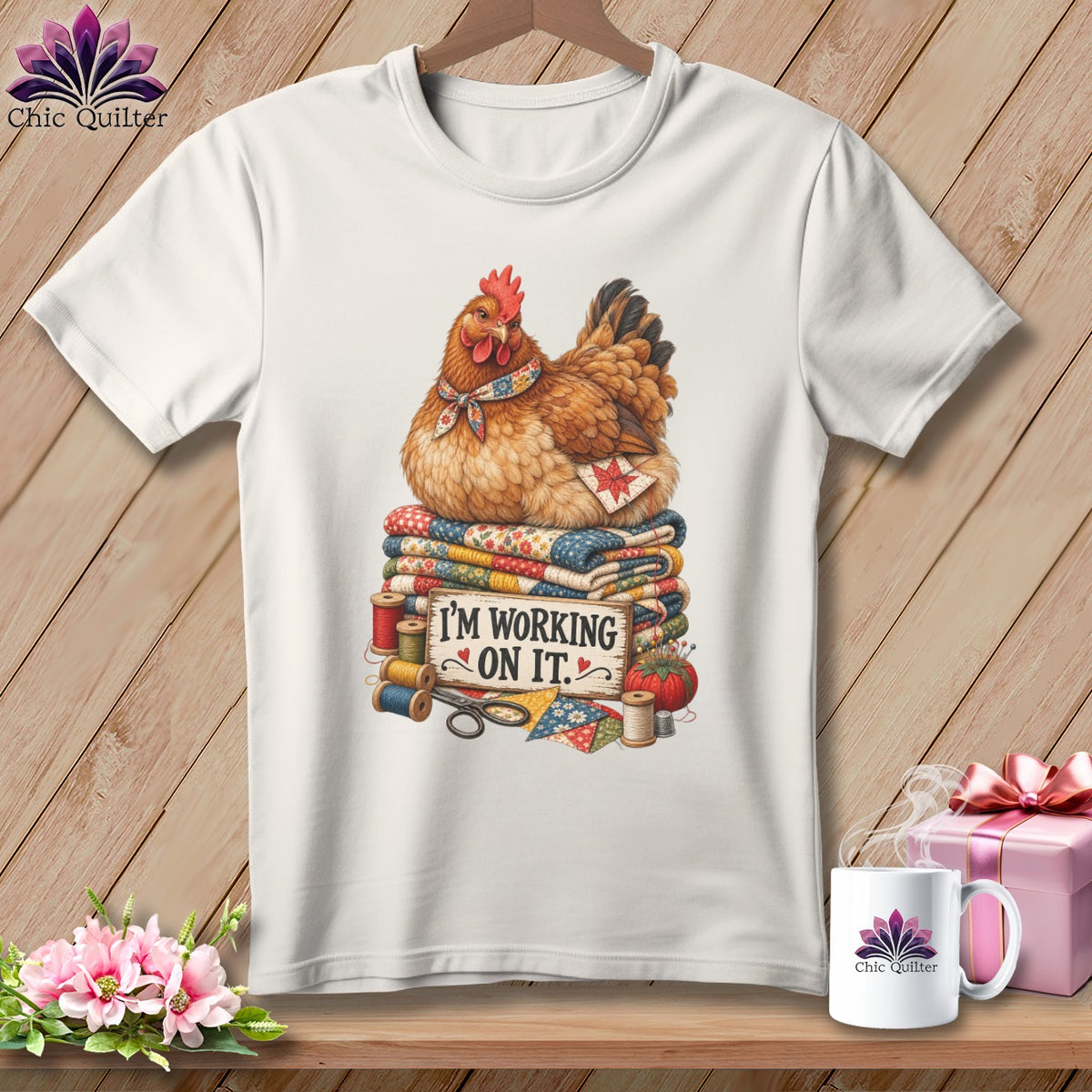 Chicken sitting on quilts with sewing supplies and "I'm working on it" text.