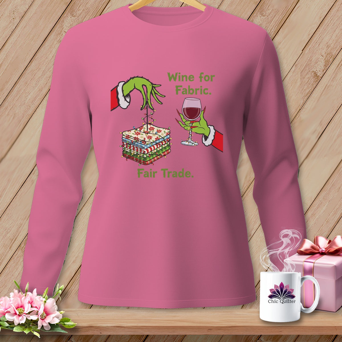Pink long-sleeve shirt with Grinch hands holding fabric and wine, text "Wine for Fabric. Fair Trade."