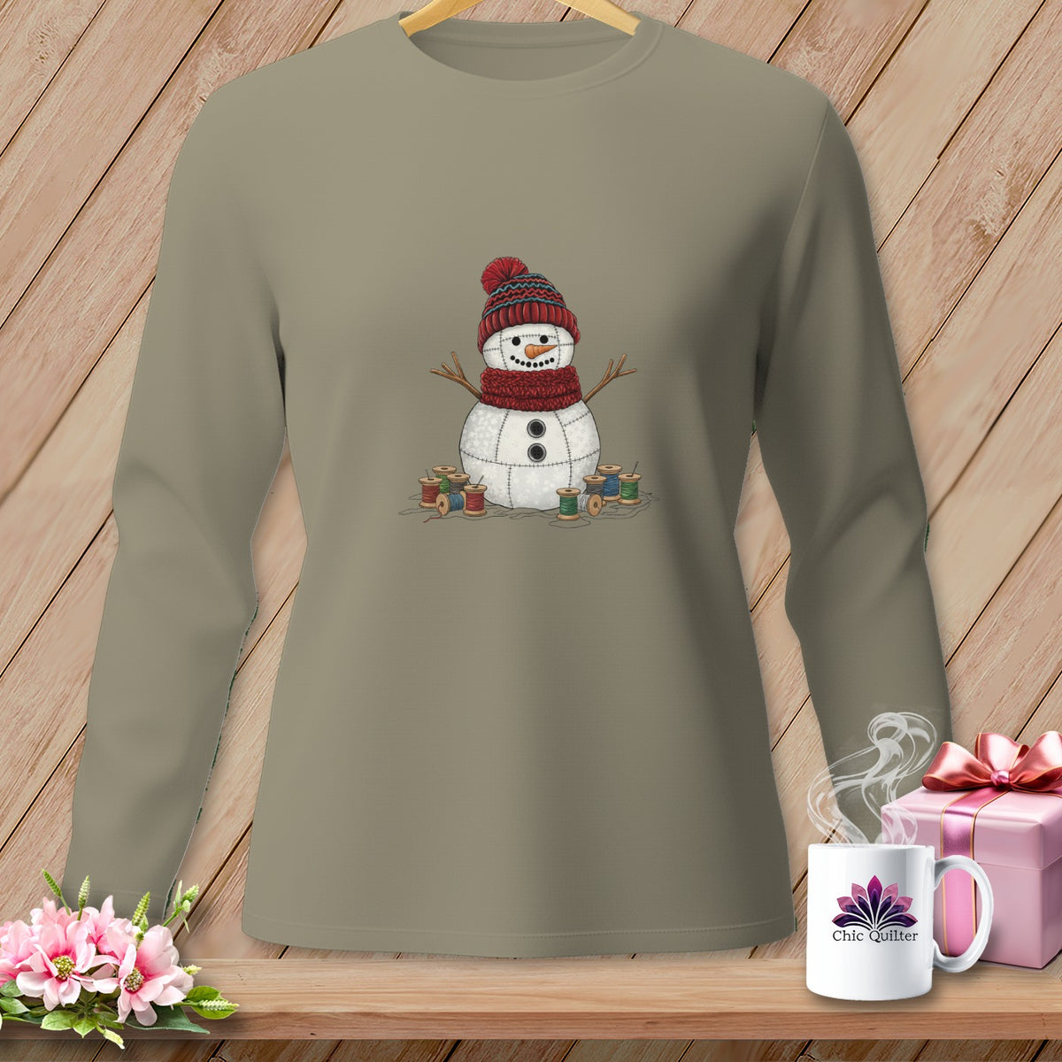 Long sleeve taupe shirt featuring a snowman graphic with spools of thread.