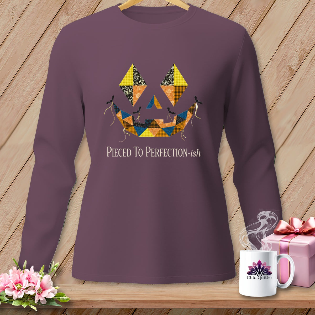 Purple long-sleeve shirt with a quilted jack-o'-lantern face and text "Pieced To Perfection-ish".