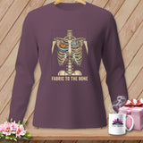 Long-sleeve shirt with skeleton ribcage filled with fabric, scissors, and pumpkin, text 