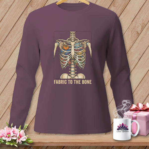 Long-sleeve shirt with skeleton ribcage filled with fabric, scissors, and pumpkin, text "FABRIC TO THE BONE".
