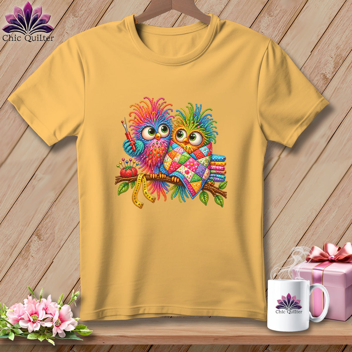 Mustard yellow t-shirt featuring a colorful graphic of two whimsical owls on a branch with sewing accessories.