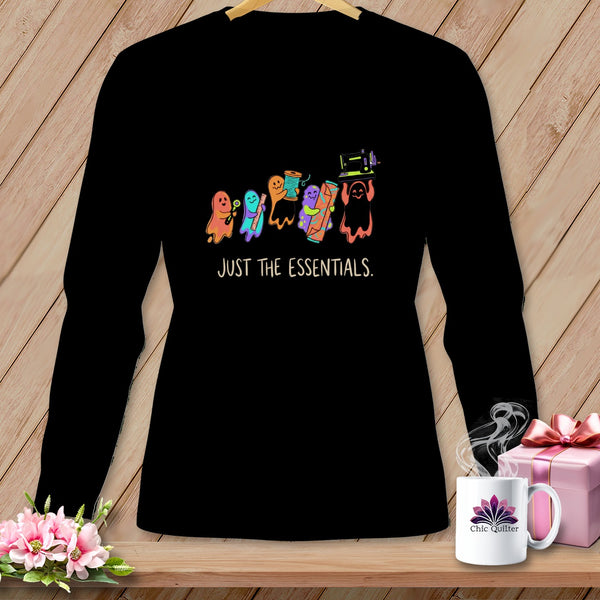 Black long-sleeve shirt with cartoon ghosts holding sewing supplies and "JUST THE ESSENTIALS." text.