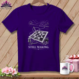 Purple t-shirt with quilt, needle, thread, scissors, and 