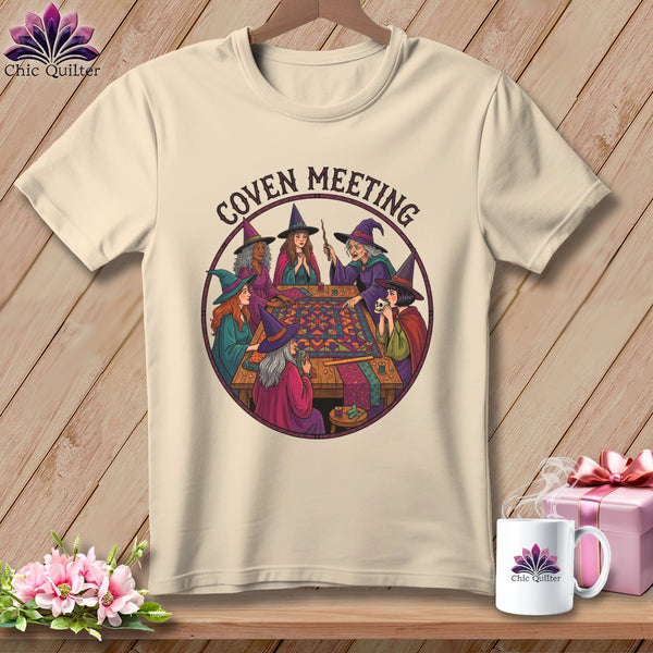Witches in hats gathered around a table quilting, with "Coven Meeting" text.