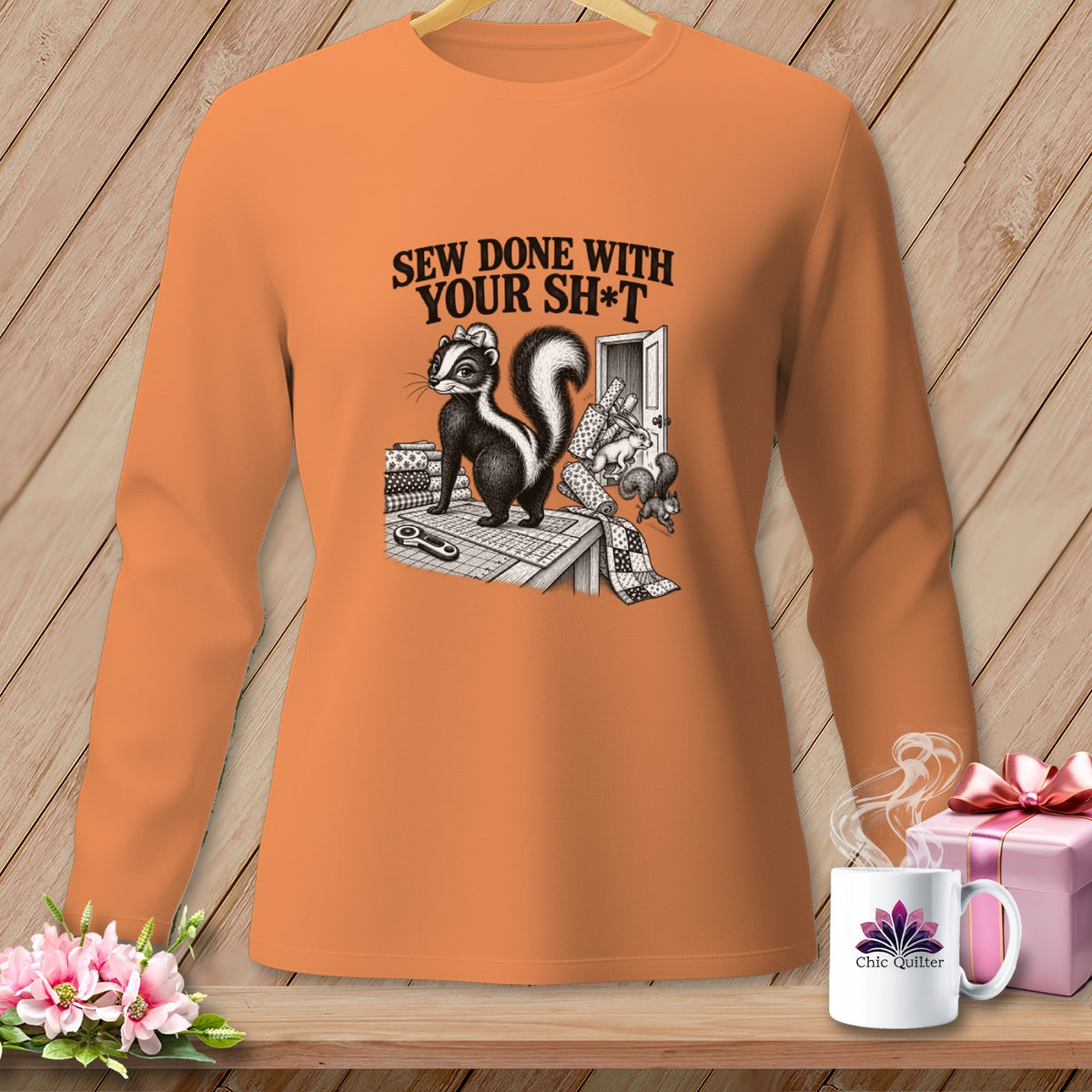 Orange long-sleeve shirt with a skunk and "Sew Done With Your Sh*t" graphic.