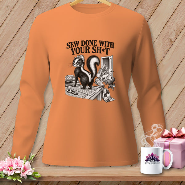 Orange long-sleeve shirt with a skunk and "Sew Done With Your Sh*t" graphic.