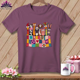 A purple t-shirt featuring a graphic of cartoon farm animals peeking over a colorful patchwork quilt.