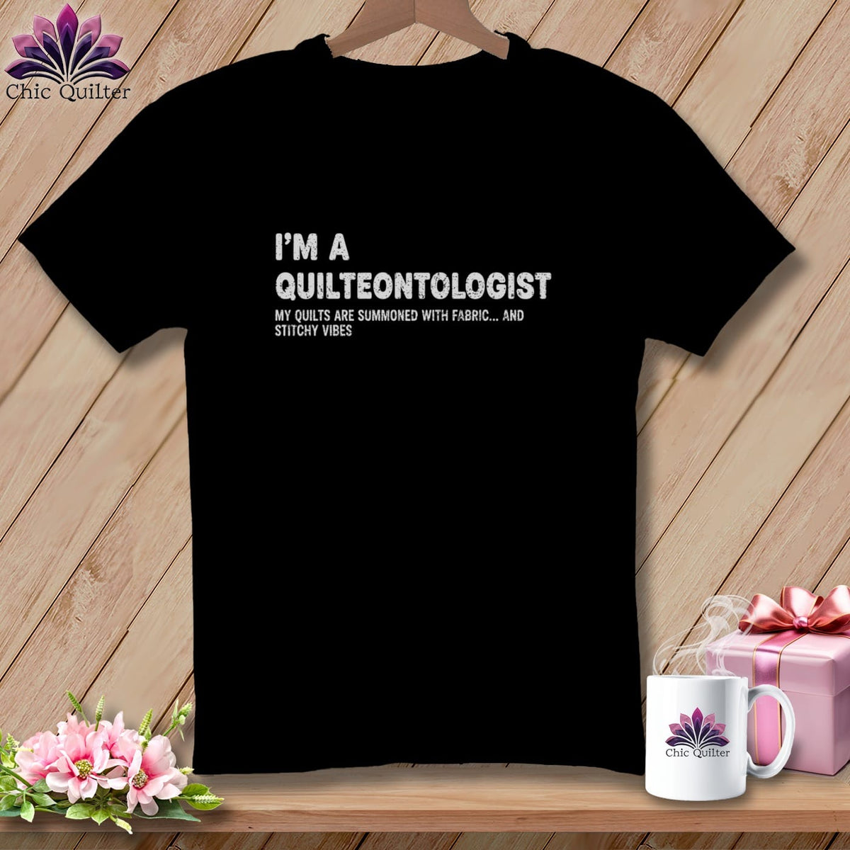 Black t-shirt with "I'M A QUILTEONTOLOGIST" and "MY QUILTS ARE SUMMONED WITH FABRIC... AND STITCHY VIBES" text.