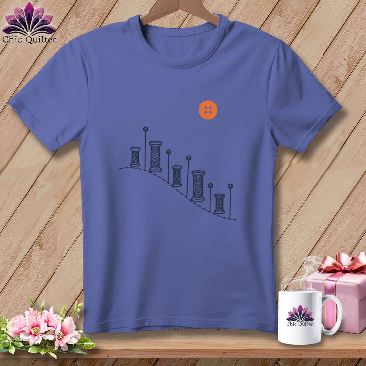 Purple t-shirt with spools of thread graphic and an orange button.
