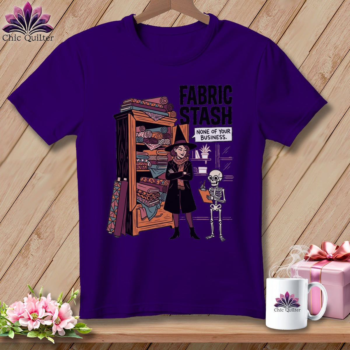 Purple t-shirt graphic of a witch and skeleton by a fabric stash.