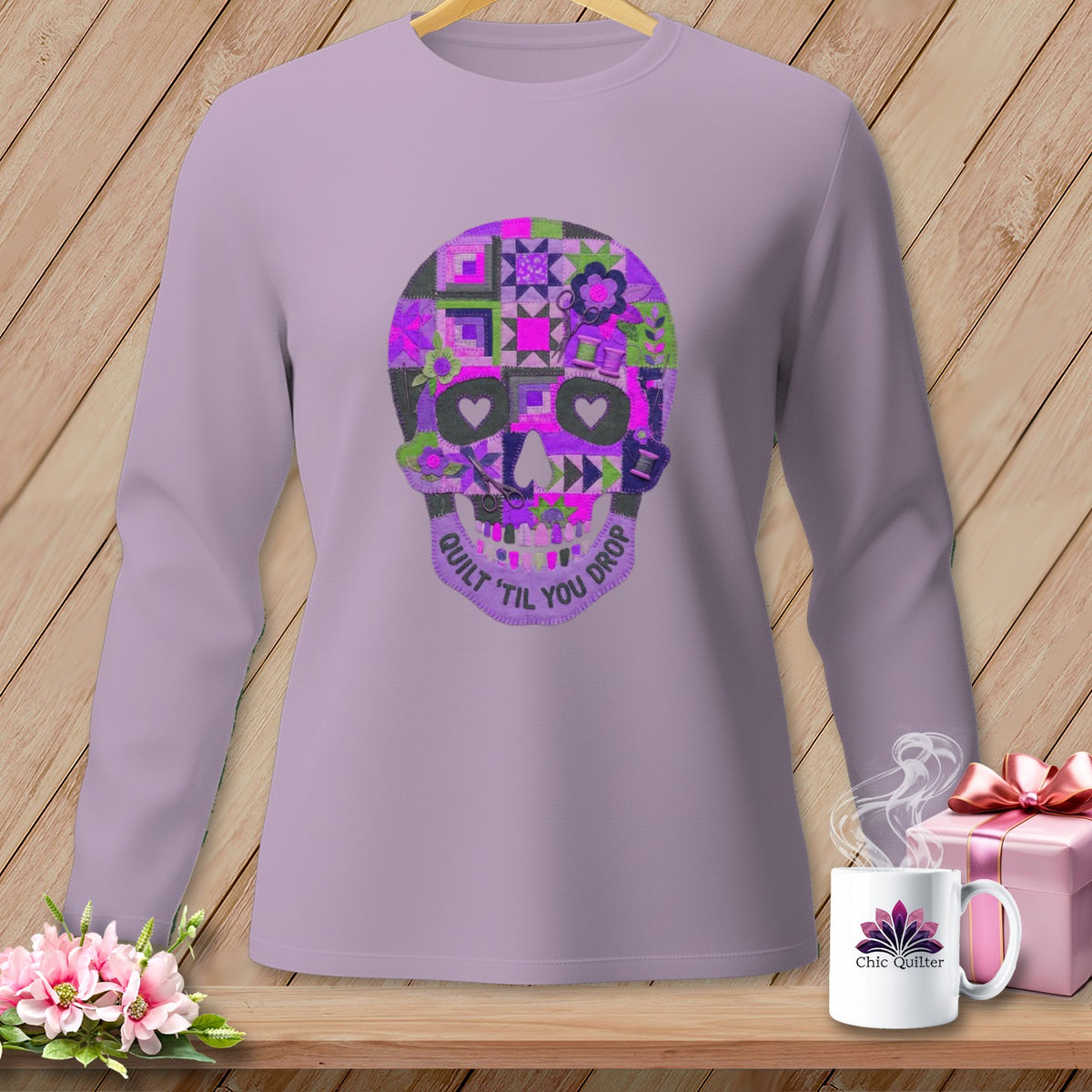 Lavender long-sleeve shirt with a quilted skull graphic and text "QUILT 'TIL YOU DROP".