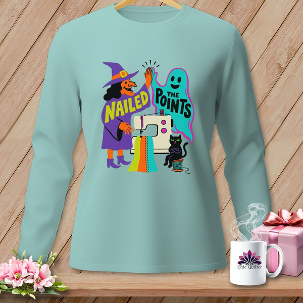 Light blue long sleeve shirt with witch, ghost, sewing machine, and black cat Halloween graphic.