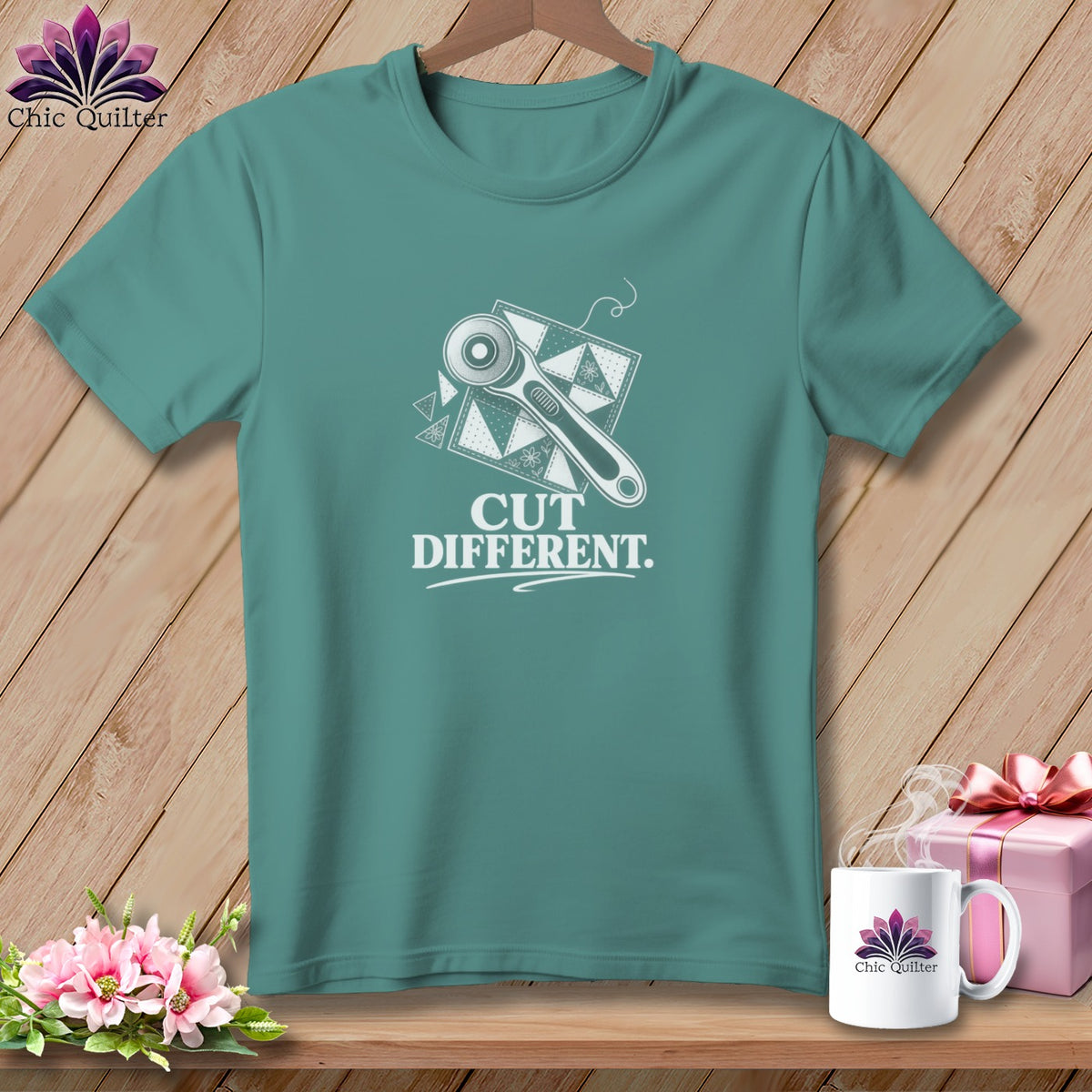 Teal t-shirt with graphic of rotary cutter on fabric and text "CUT DIFFERENT."