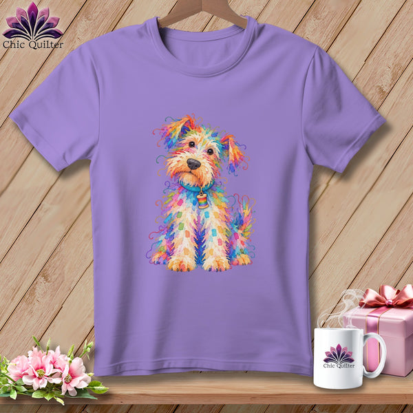 A lavender t-shirt hangs on a wooden hanger, featuring a colorful watercolor illustration of a scruffy dog.