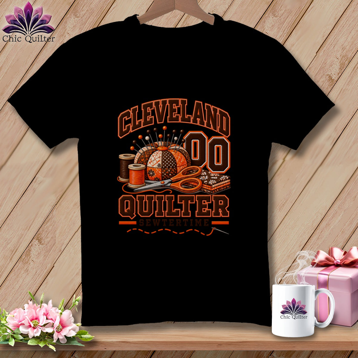 Black t-shirt featuring a Cleveland Quilter graphic with a pincushion, thread, scissors, and folded fabric.
