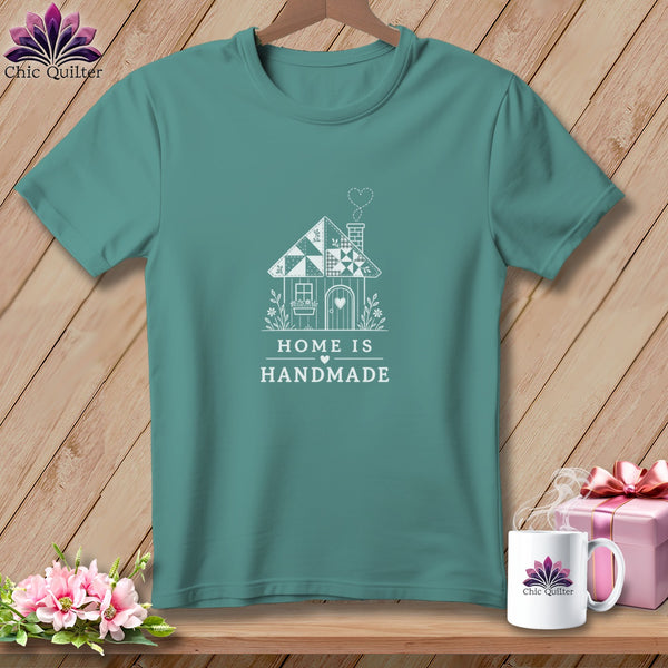 Teal t-shirt with white graphic of a house and text "HOME IS HANDMADE".