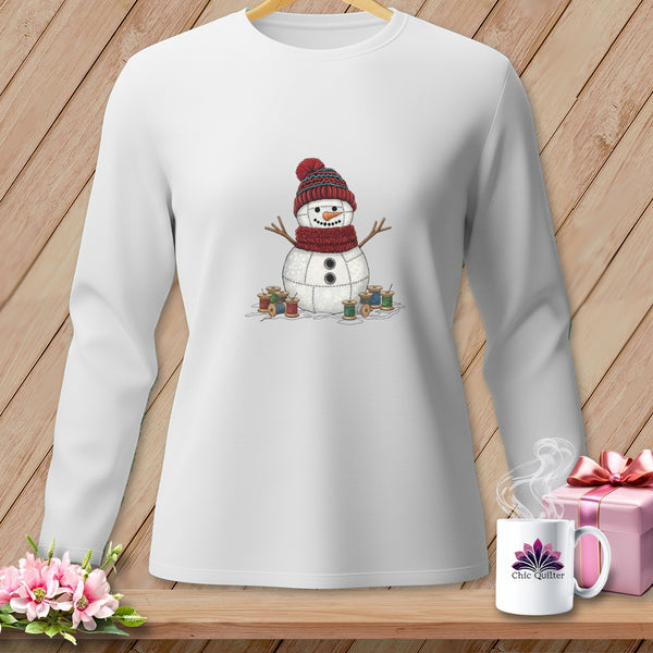 White long-sleeved shirt with a stitched snowman graphic surrounded by spools of thread.