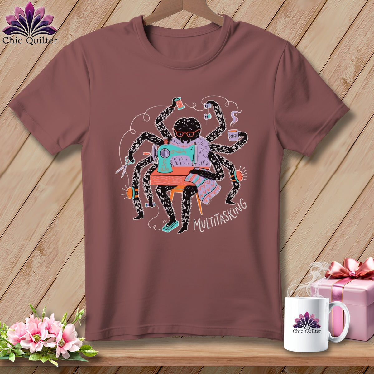 Spider sewing at a machine with text "MULTITASKING" on a maroon t-shirt.