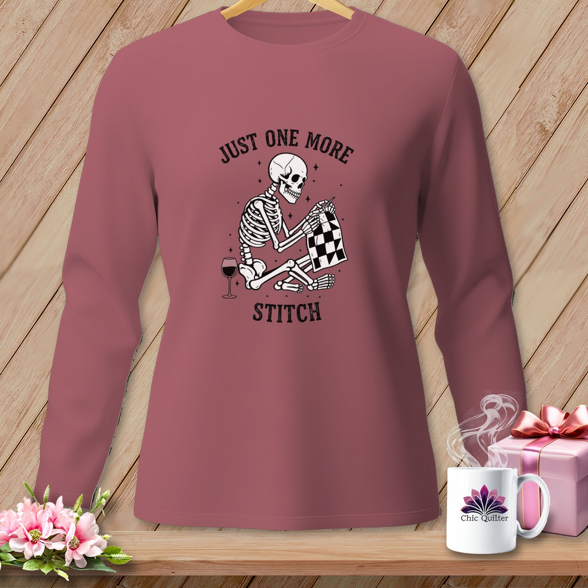 Skeleton sewing with wine glass and text "Just One More Stitch".