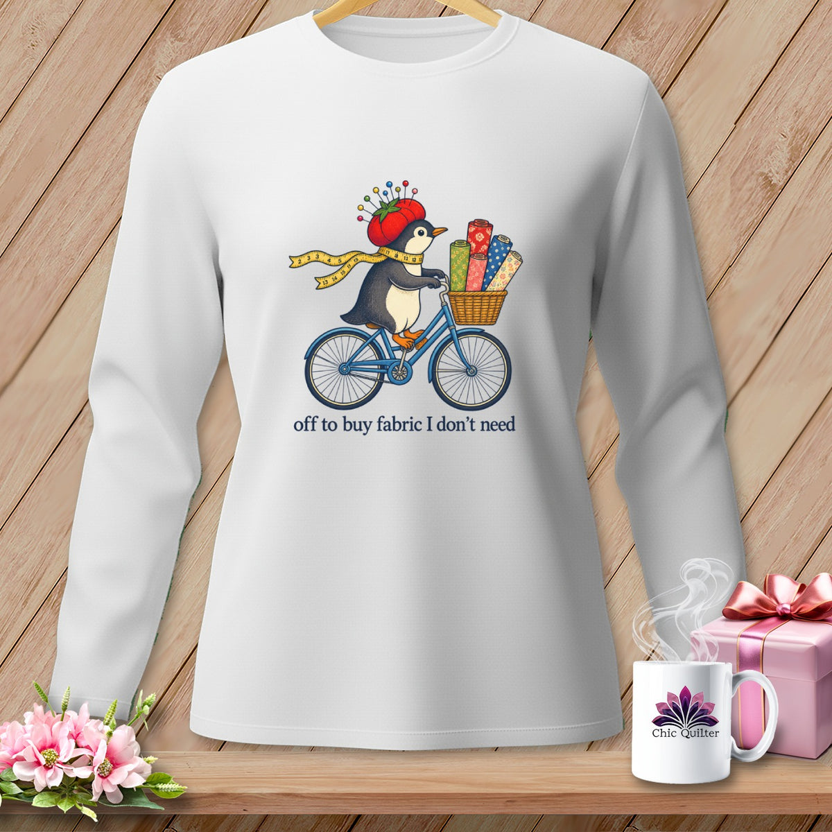 Penguin on bicycle with fabric rolls, "off to buy fabric I don't need."