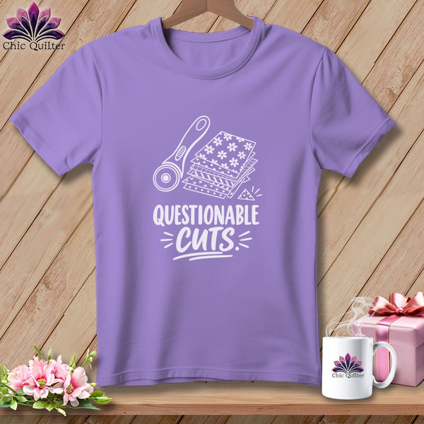 Lavender t-shirt with graphic of rotary cutter and fabric stacks, text "Questionable Cuts".