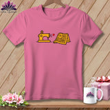 Pink t-shirt with a graphic of a yellow sewing machine, a red heart, and a folded yellow quilt.
