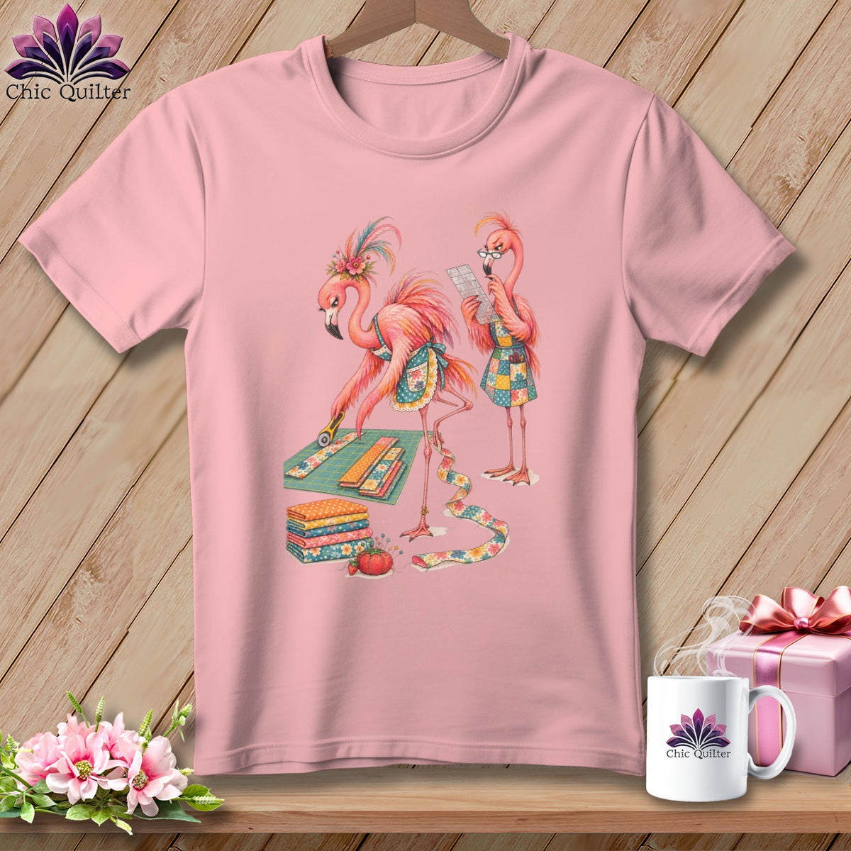 Pink t-shirt with two flamingos quilting, one cutting fabric and the other reading instructions.