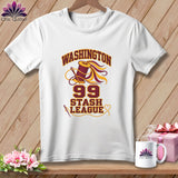 A white t-shirt hanging on a wooden background, featuring a sewing graphic with the text Washington 99 Stash League.