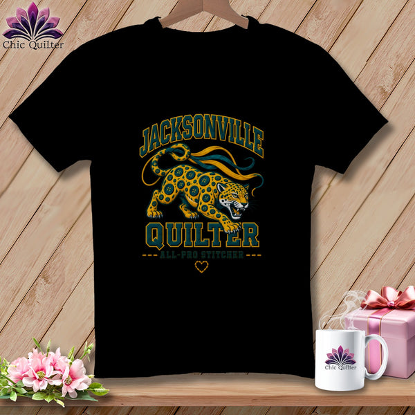 Black t-shirt featuring a Jacksonville Quilter graphic with a spotted cat design and text.