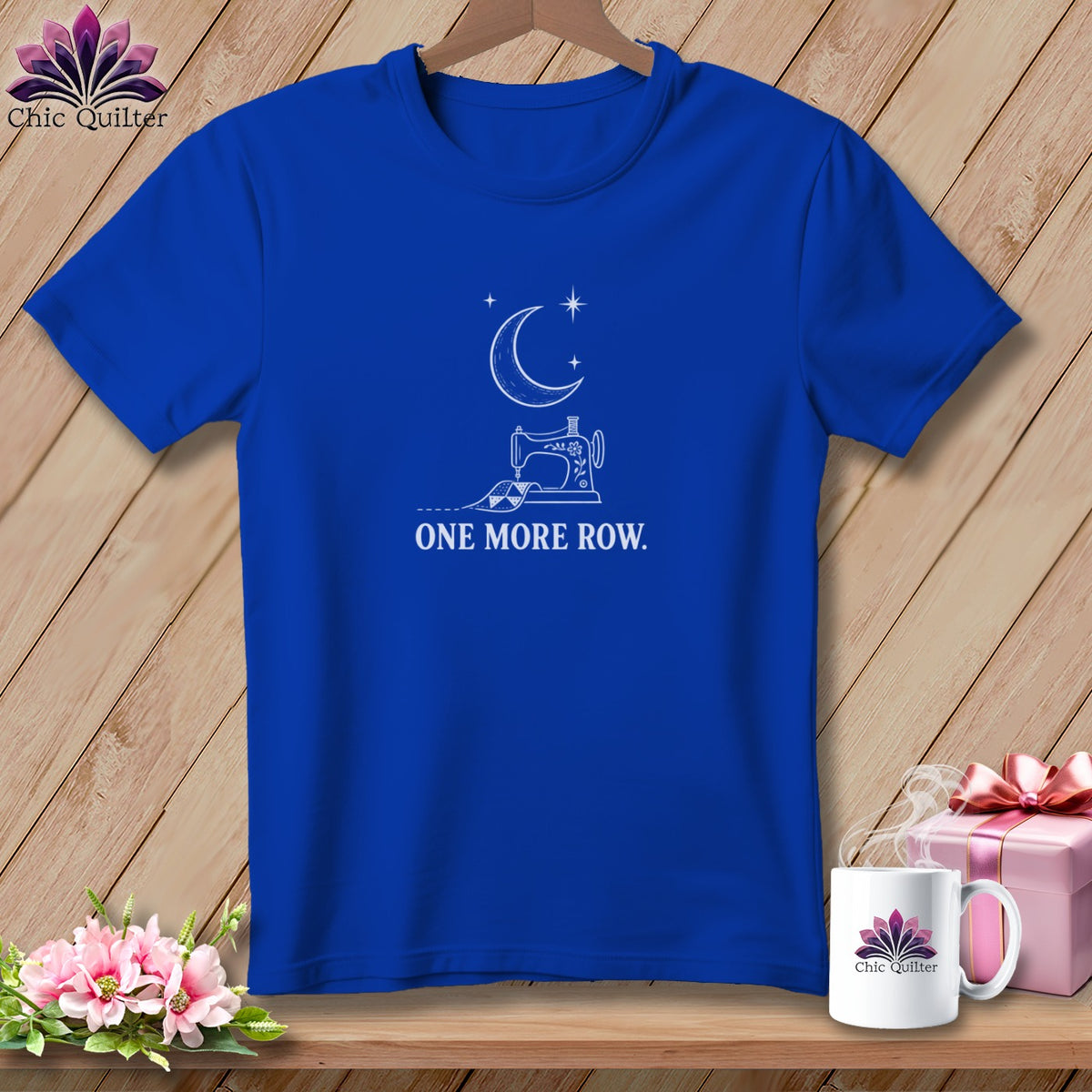 Blue t-shirt with white sewing machine, moon, stars, and text "ONE MORE ROW."