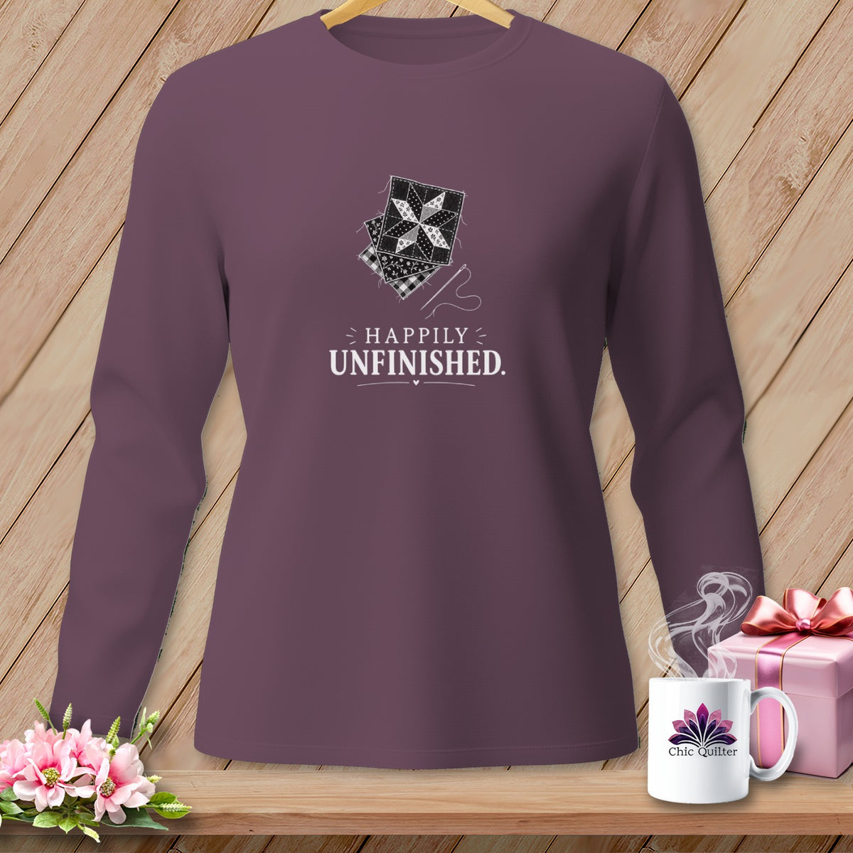 Long-sleeve shirt with quilting squares graphic and "Happily Unfinished" text.