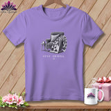 Purple t-shirt with an illustration of a chair, quilt, and text 