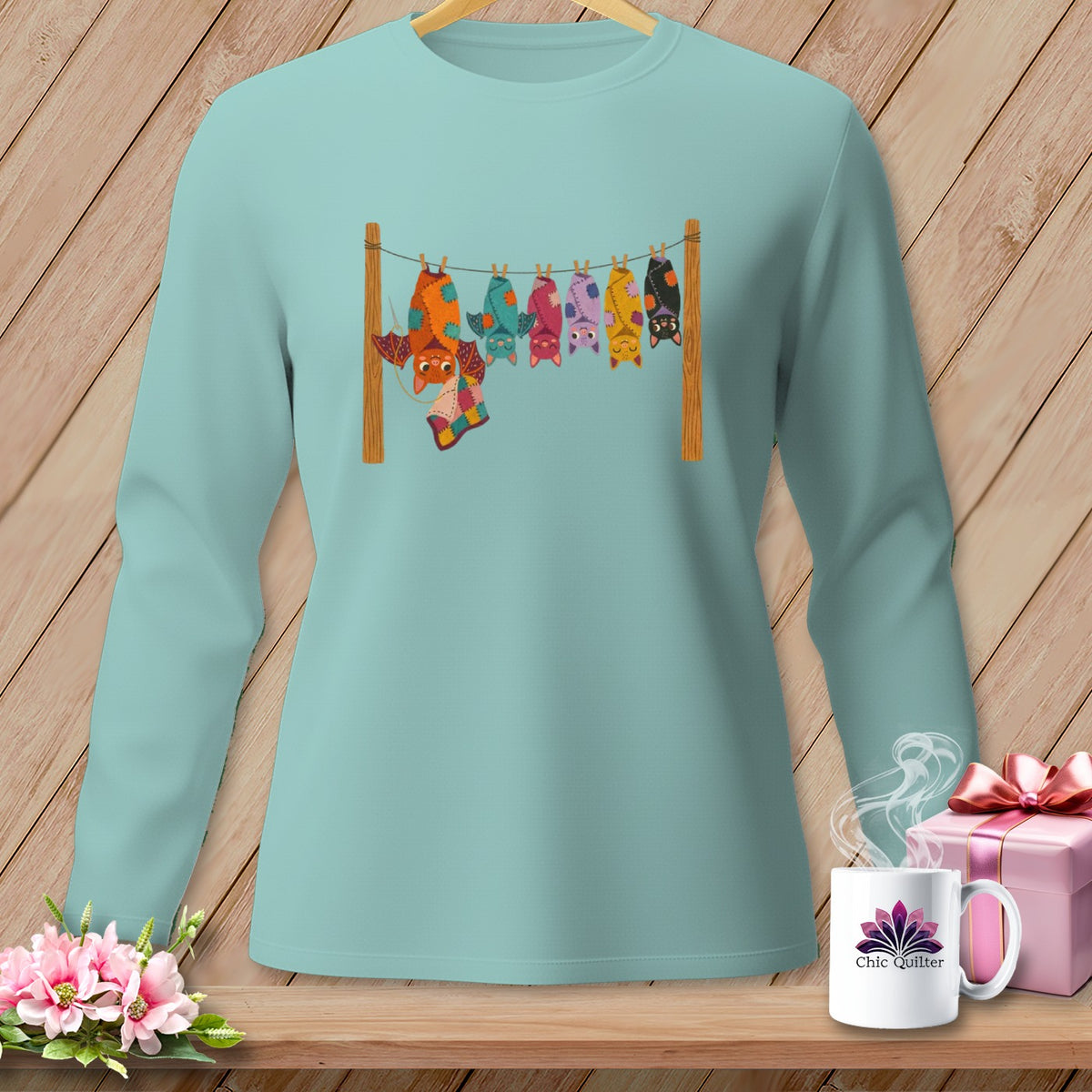Mint long-sleeve shirt with colorful bats hanging on a clothesline.