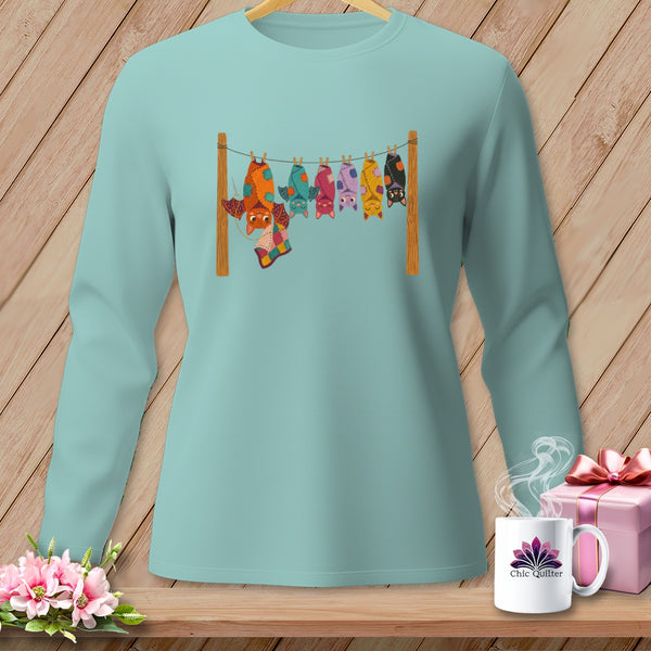 Mint long-sleeve shirt with colorful bats hanging on a clothesline.