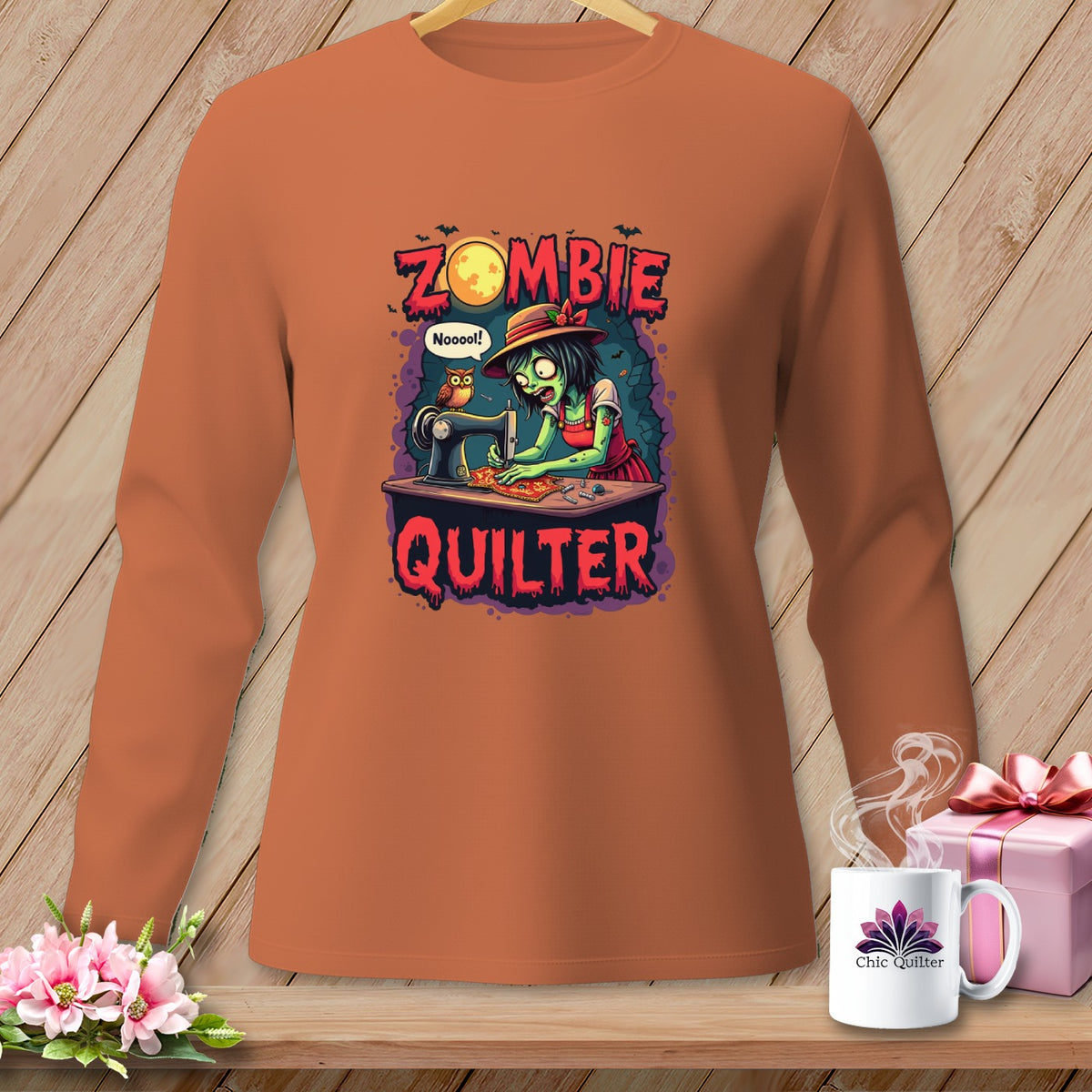 Orange long-sleeve shirt with "Zombie Quilter" graphic of a zombie at a sewing machine.