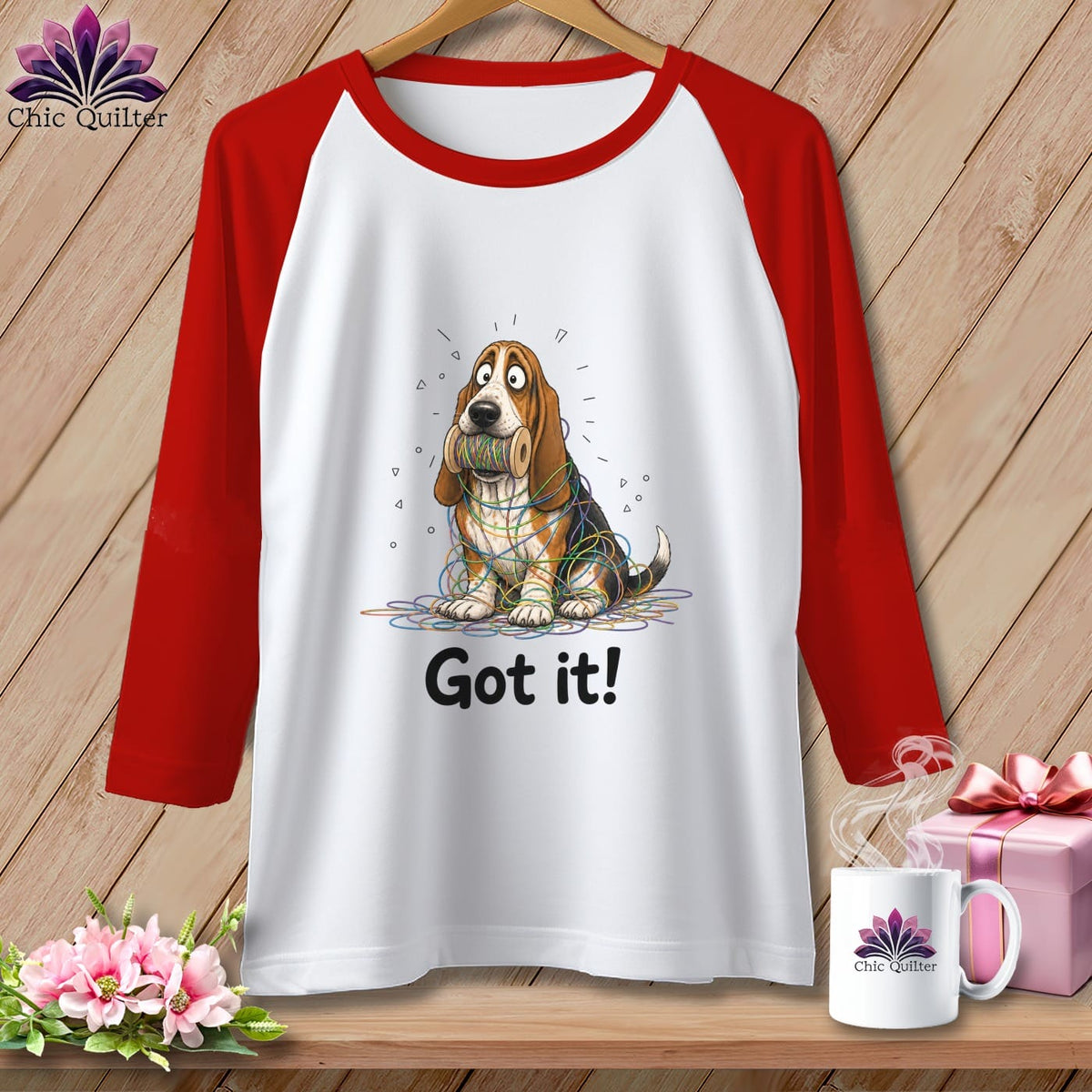 White raglan shirt with red sleeves featuring a basset hound tangled in colorful yarn and text "Got it!".