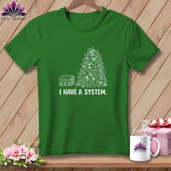 Green t-shirt with a stack of fabric scraps and the text "I HAVE A SYSTEM."