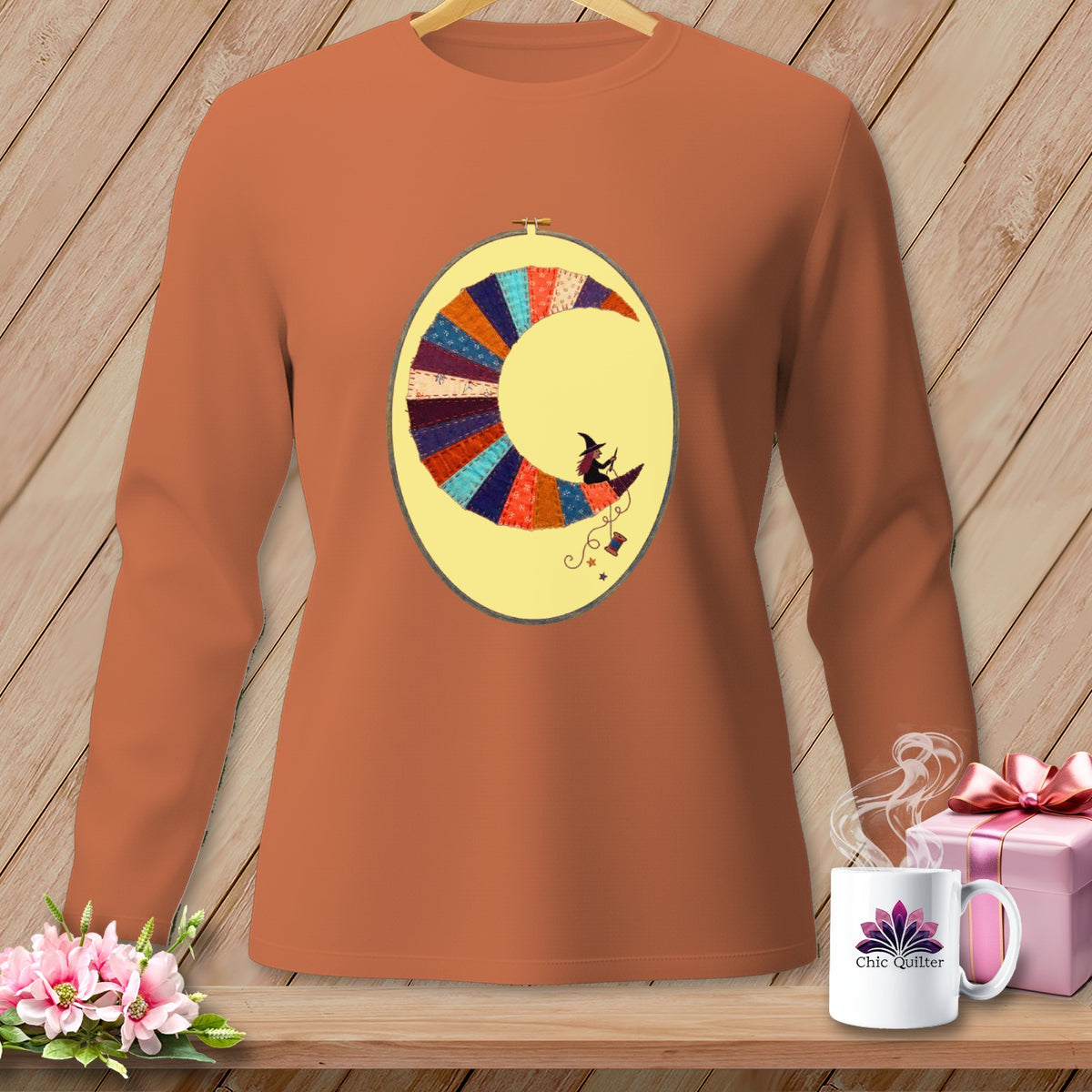 Long-sleeve burnt orange t-shirt with a crescent moon quilt design and a witch riding a broom.