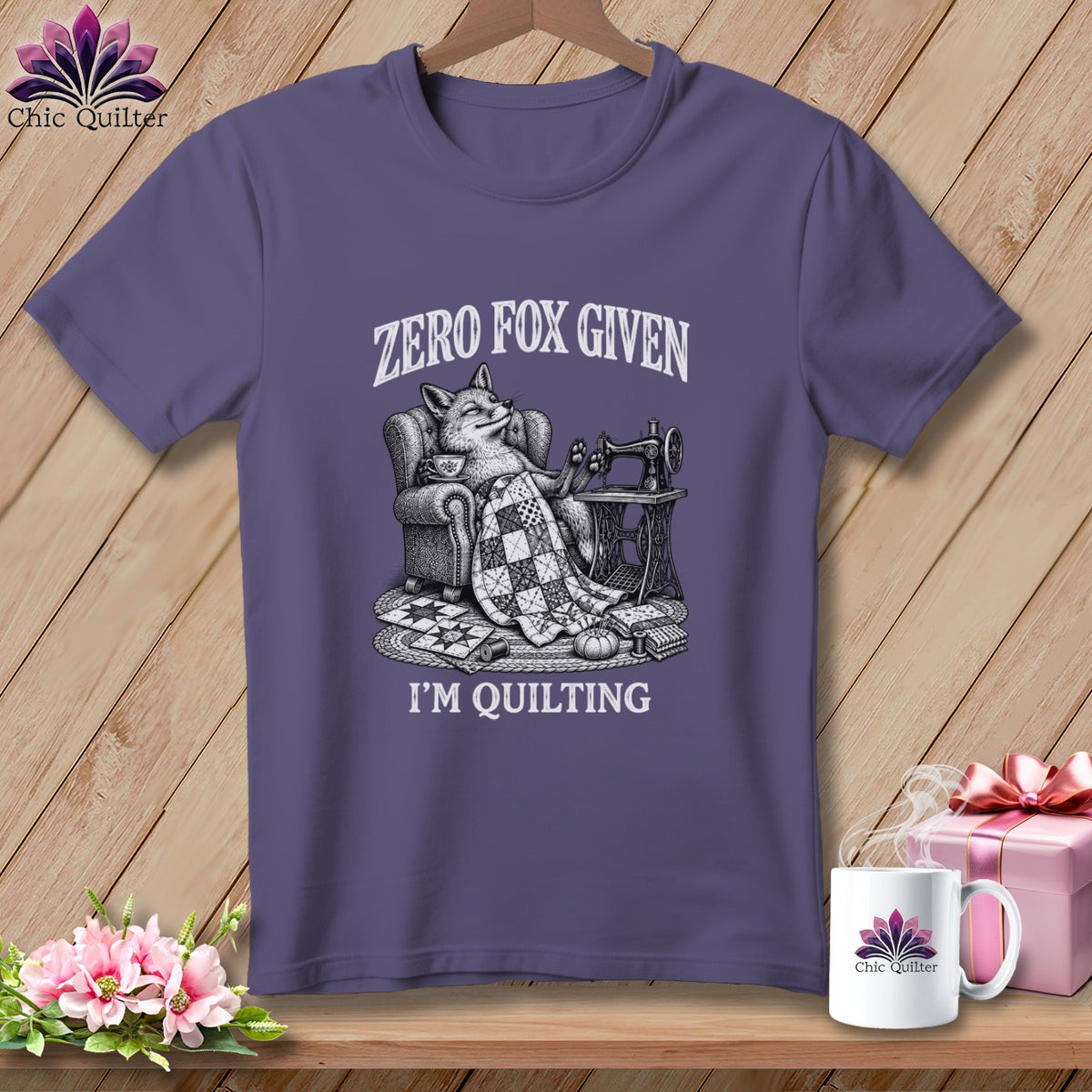 T-shirt with graphic of fox in chair with sewing machine and quilt, text reads "Zero Fox Given I'm Quilting".