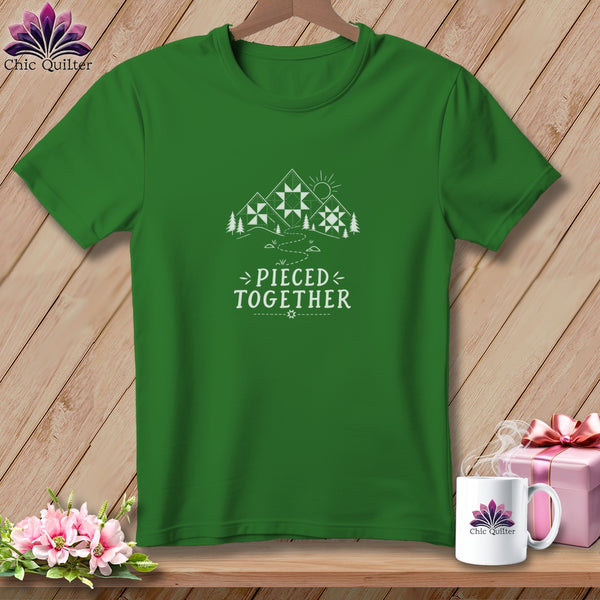 Green t-shirt with a mountain scene, sun, and text "Pieced Together".