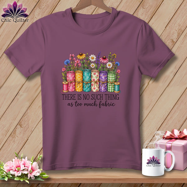 Mauve short-sleeve t-shirt with a colorful graphic of rolled fabric, flowers, and the text "There is no such thing as too much fabric."