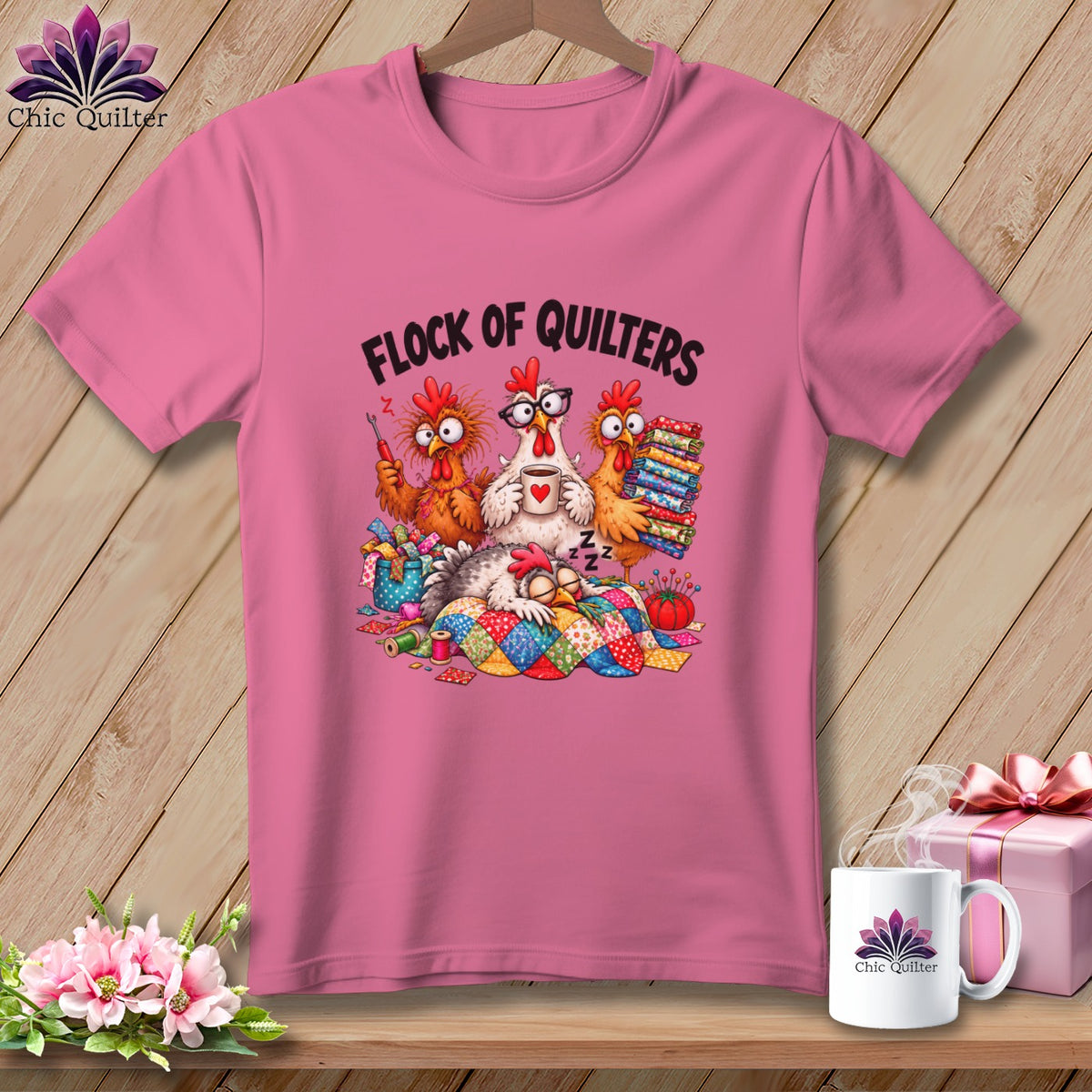 Pink t-shirt with a graphic of cartoon chickens quilting and the text Flock of Quilters.