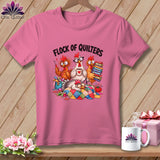 Pink t-shirt with a graphic of cartoon chickens quilting and the text Flock of Quilters.